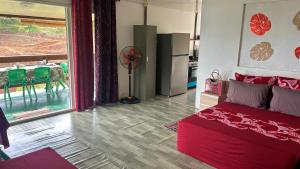 a bedroom with a red bed and a table with chairs at KOKI Horizon in Atuona