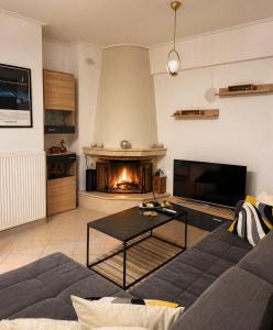 a living room with a couch and a fireplace at H&H cozy retreat ,Fireplace and Parking in Piraeus