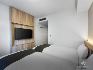 a bedroom with a bed and a flat screen tv at Daiwa Roynet Hotel Nagoya Eki Mae in Nagoya