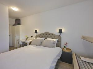 a bedroom with a large white bed and a desk at Jantjes Tuin in Mall