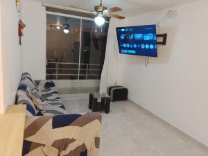 a living room with a flat screen tv on a wall at departamento familiar privado trujillo huanchaco in Huanchaco