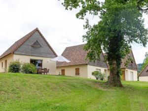 a house on a grassy hill with a tree at Lac Bleu nr 10 in Lacapelle-Marival