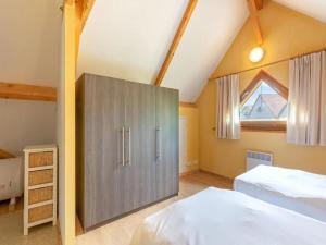 a attic bedroom with two beds and a cabinet at Lac Bleu nr 10 in Lacapelle-Marival
