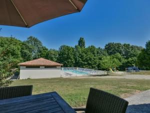 a picnic table with an umbrella and a playground at Lac Bleu nr 10 in Lacapelle-Marival