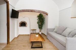 a living room with a couch and a table at Amaryllis Suites Santorini in Fira
