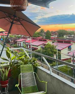 a balcony with a chair and an umbrella at Amazon House Hostel in Iquitos +27 photos
