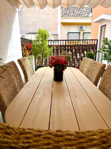a wooden table with a vase of flowers on a balcony at Casa Natali in Fuengirola