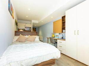 a bedroom with a white bed and a kitchen at For Students Only - Central Studios in Reading in Reading +10 photos