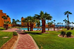 a park with palm trees and a swimming pool at Ocean Front PRINCESA Resort D108-Sandy Beach-Ground Floor-HUGE in Puerto Peñasco