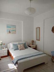 a white bedroom with a bed and a mirror at NiK Seaview Suite Balcony Steps from Beach in Flogita