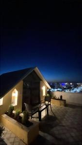 a patio with a bench on a roof at night at North paradise hotel in Irbid