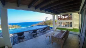 a large swimming pool on a patio with a view of the ocean at Casa Sacre in Cuatunalco