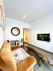 a living room with a couch and a tv on the wall at Dushi Apartments in Willemstad