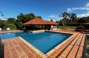 a large swimming pool with a gazebo at Chalet La Estancia - Parque del Café in Montenegro