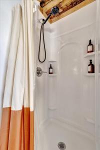 a shower with an orange and white shower curtain at Peaceful Studio & Work Friendly Walk to Hyde Park in Tampa +2 photos