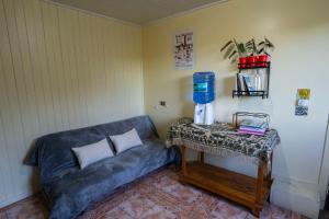 a living room with a blue couch and a table at Hostal refugio nomada in Puerto Montt