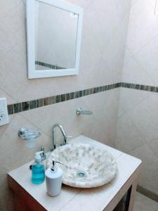 a bathroom with a sink with a mirror and a mirror at Misky Sonqo in Tilcara