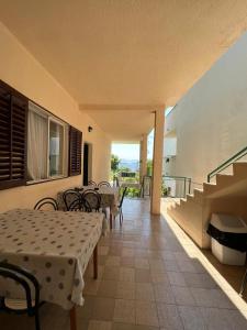 eine Terrasse mit Tischen und Stühlen und ein Balkon in der Unterkunft Rooms with shared kitchen "Milica" in Drvenik