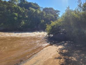 a view of a river with trees and a beach at Parque Parapirá Camping in Socorro