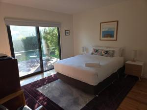 a bedroom with a large bed and a large window at SeymourViews Apollo Bay in Apollo Bay