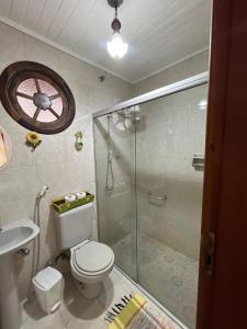 a bathroom with a shower and a toilet and a sink at Pousada Laço e Nó in Itatiaia