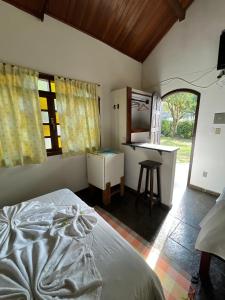 a bedroom with a bed and a sink and a counter at Pousada Laço e Nó in Itatiaia