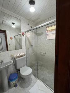a bathroom with a shower and a toilet and a sink at Pousada Laço e Nó in Itatiaia