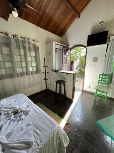 a bedroom with a bed and a kitchen with a counter at Pousada Laço e Nó in Itatiaia