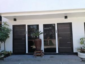 a house with two garage doors and a potted plant at Anabelle Residence in Dumaguete