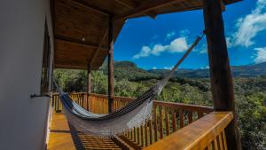 a hammock on a porch with a view of the mountains at Chalé Morada das estrelas in Aiuruoca