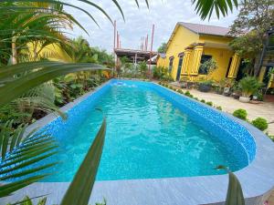 a blue swimming pool in front of a house at Peace Homestay Hoa Lư in Xuân Sơn