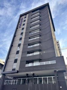 a tall building with a sign on the side of it at Studio moderno com cozinha completa e Wi-Fi centro in Barbacena