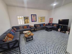 a living room with couches and a flat screen tv at VILLA KEUR BAYE FALL Saly in Sali Nianiaral
