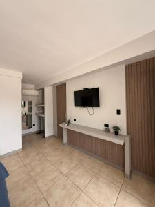 a living room with a flat screen tv on a wall at Guayacan Real in Nicoya