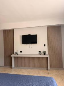 a flat screen tv on a wall in a room at Guayacan Real in Nicoya