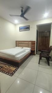 a bedroom with a bed and a desk and a chair at RK Residency Hotel & Resturant in Ukhimath