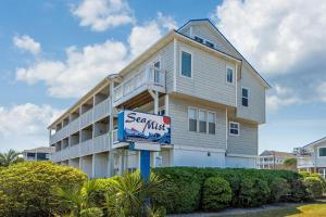 a large apartment building with a sign in front of it at Co Sea Casa in Carolina Beach