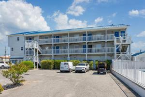 a large building with cars parked in a parking lot at Co Sea Casa in Carolina Beach