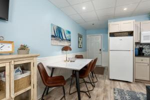 a kitchen with a table and chairs and a refrigerator at Co Sea Casa in Carolina Beach +11 photos