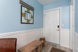 a room with blue walls and a wooden bench at Co Sea Casa in Carolina Beach