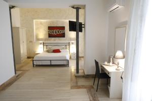 a bedroom with a bed and a desk with a desk at B&B Liberty 900 in Catania