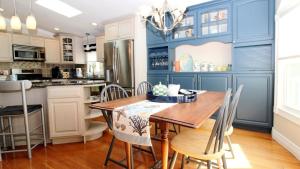 a kitchen with blue walls and a wooden table and chairs at Sunset Shore House Second Floor in West Cape May