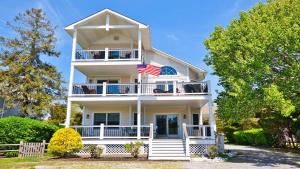 a white house with an american flag on it at Sunset Sands And Sea Dogs in West Cape May