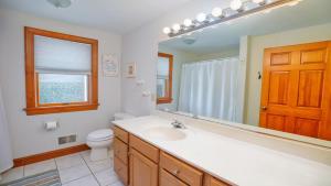 a bathroom with a sink and a toilet and a mirror at Sunset Sands And Sea Dogs in West Cape May +28 photos