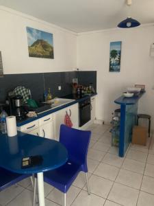 eine Küche mit einem blauen Tisch und blauen Stühlen in der Unterkunft Lechampfleury in Garnier