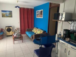 ein Wohnzimmer mit einer Couch und einer blauen Wand in der Unterkunft Lechampfleury in Garnier