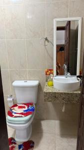 a bathroom with a toilet and a sink at Casa no centro de Serra Negra in Bezerros