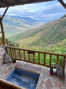 a hot tub on a balcony with a view of mountains at Mambe refugio in Piedecuesta +29 photos