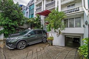 a green car parked in front of a house at RedDoorz Plus @ Guntur Raya Setiabudi in Jakarta