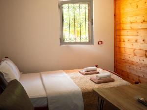 a bedroom with a bed and a window and a table at Arditi's Villa in Shkodër